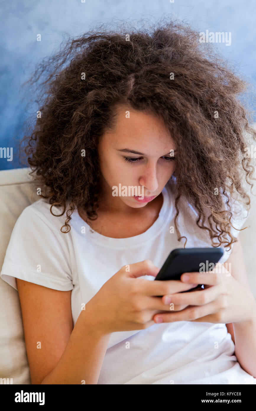 Cute teen curly hair girl with mobile phone Stock Photo