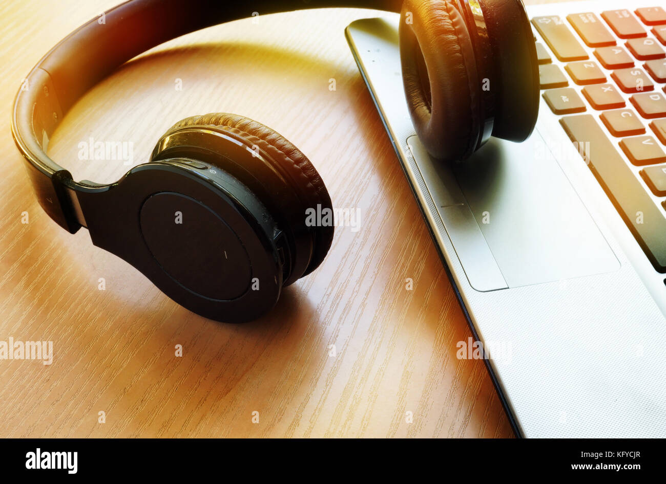 Audio podcast or music in internet concept. Headphones on a notebook. Stock Photo