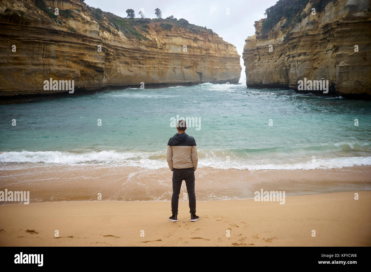 sheltered bay in Australia and man stands with hands in his pockets at the beach Stock Photo