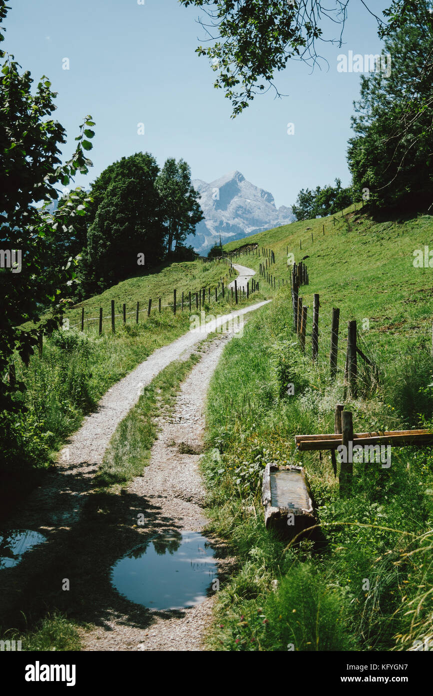 HIking path in the German Alps with a water well by the road Stock Photo