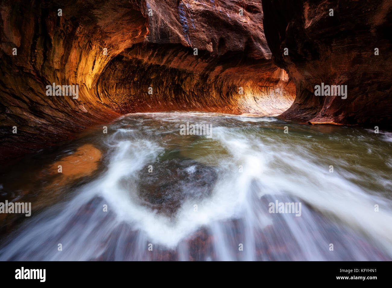 Beautiful shot of Subway tunnel with golden sunlight reflection in Zion National Park, Utah, USA. Hiking over water fall. Stock Photo