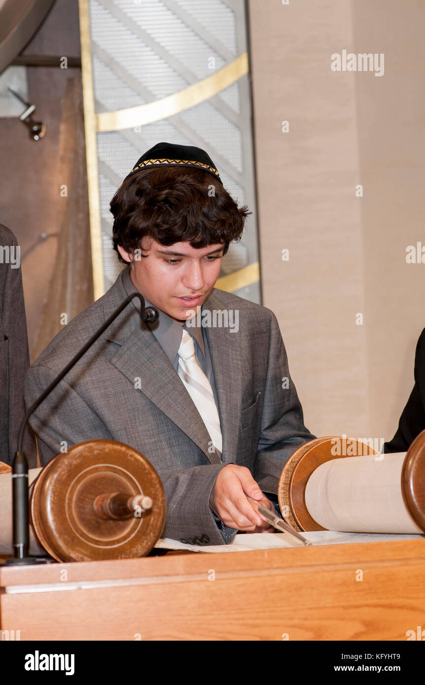 Minnetonka, Minnesota. 14 year old boy practicing for his Bar Mitzvah at Bet Shalom Congregation Synagogue.  Reading a Torah scroll with a yad. Stock Photo