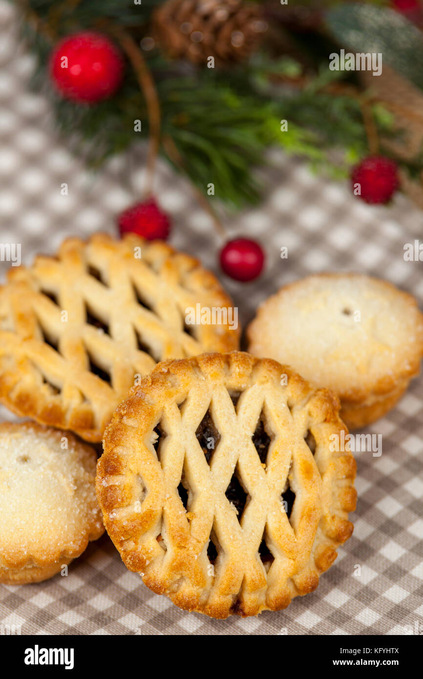 Frsh lattice top mince pies on a country table with some festive seasonal christmas decorations Stock Photo