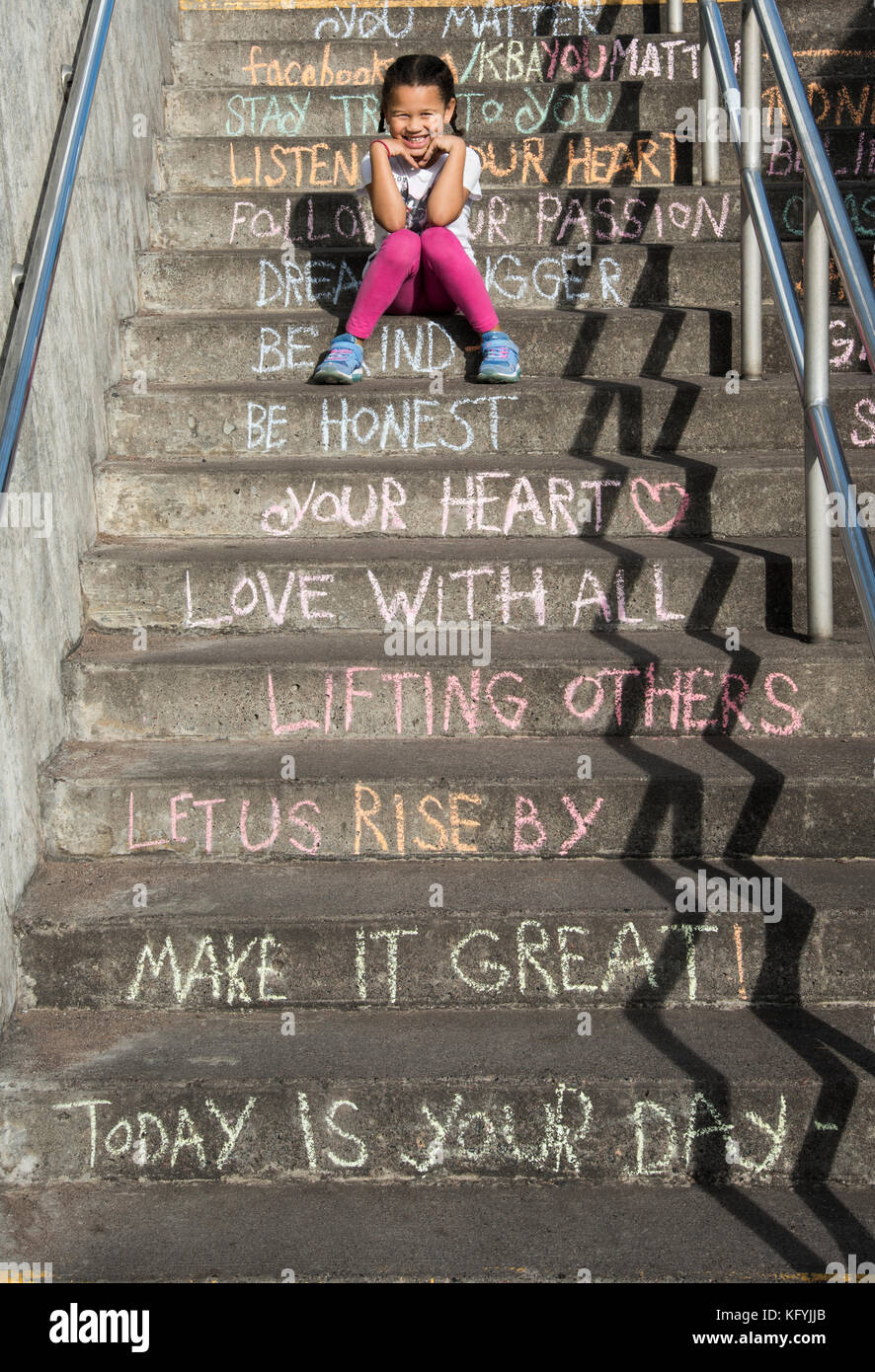 Duluth, Minnesota. Five year old bi-racial girl sitting on the stairs of inspiration. Stock Photo