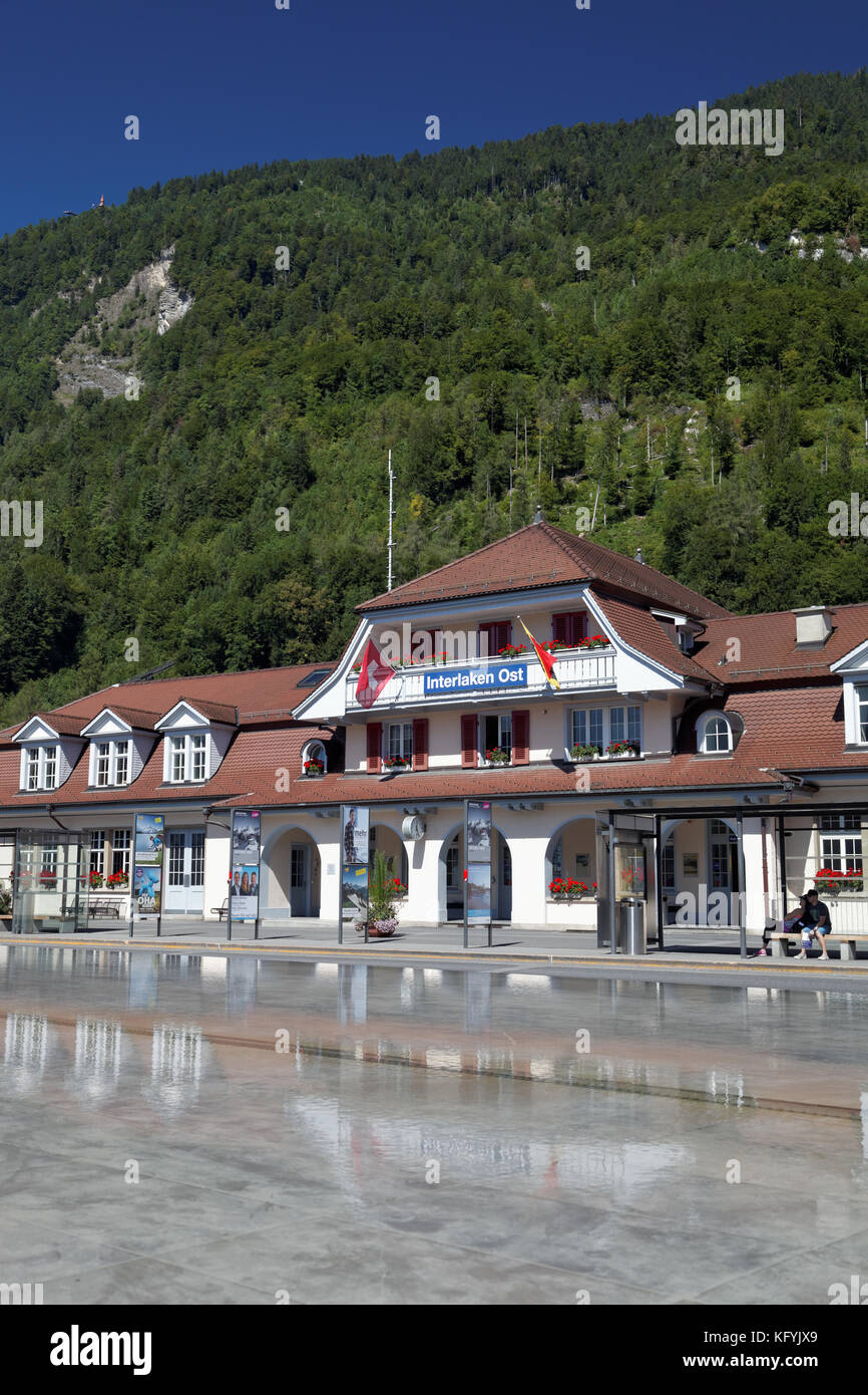 Interlaken Ost or Interlaken East railway station reflected in pool, Interlaken, Switzerland Stock Photo