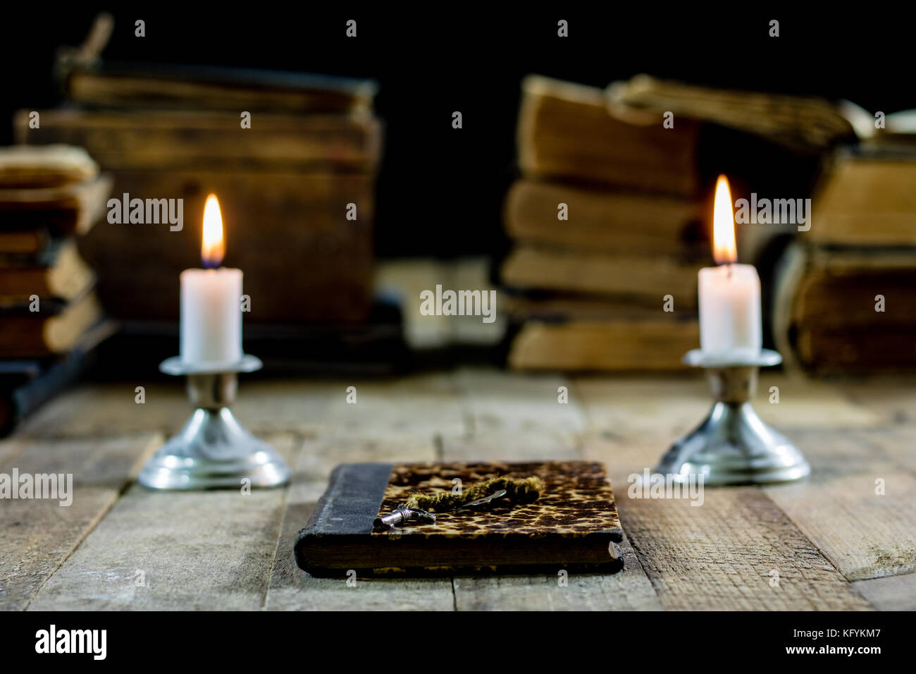Old books and candles on a wooden table. Old room, reading room. Black