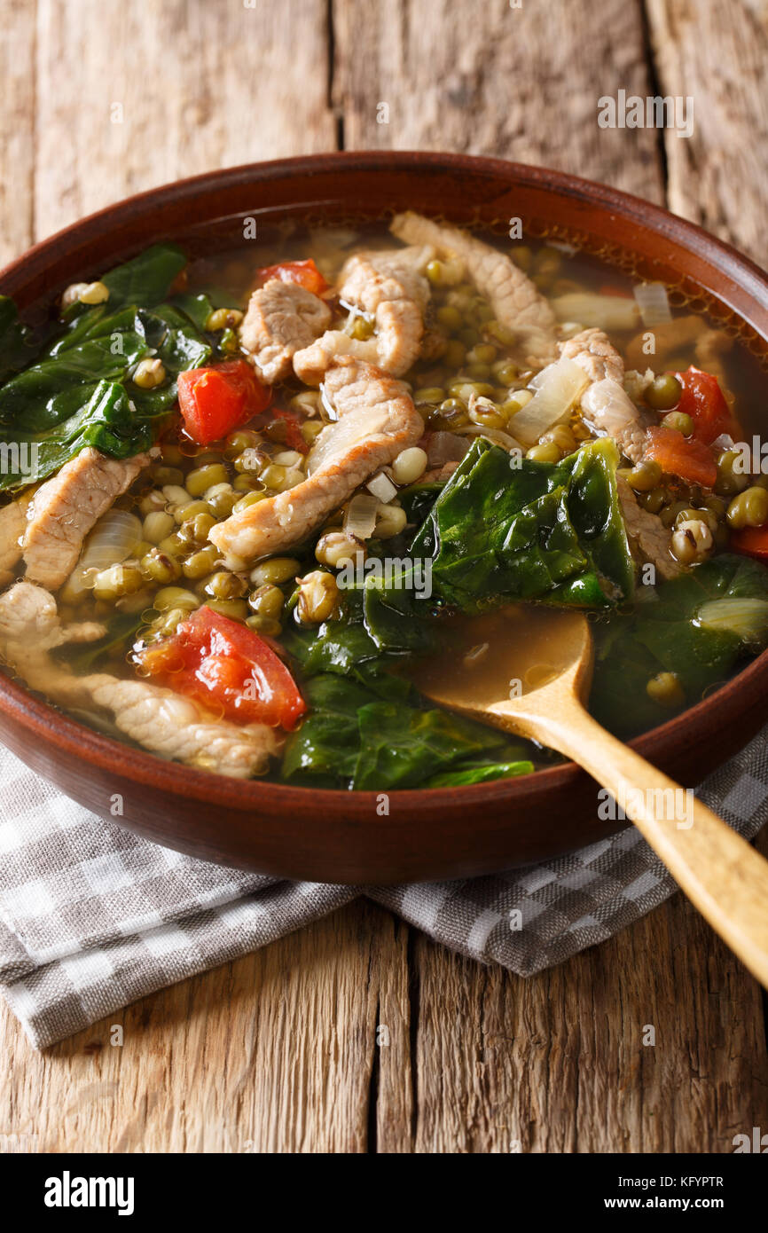 Filipino Ginisang Munggo is a delicious mung bean stew flavored with pork on the table. Vertical Stock Photo