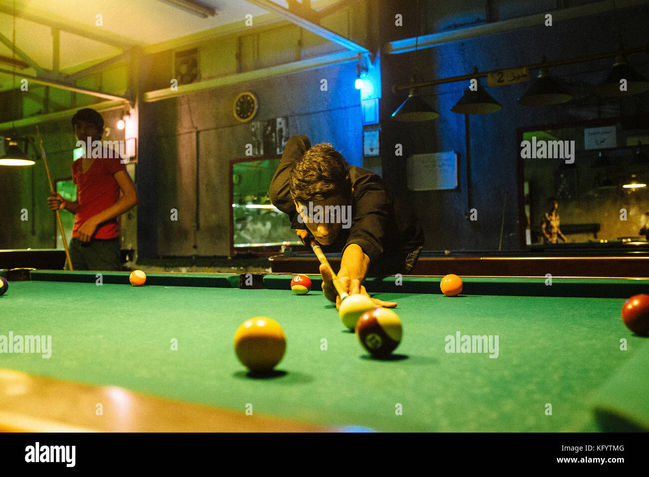 Bandar Abbas, Iran - December 14, 2013. Young Iranian men are playing billiard at a billiard hall in Bandar Abbas. Stock Photo
