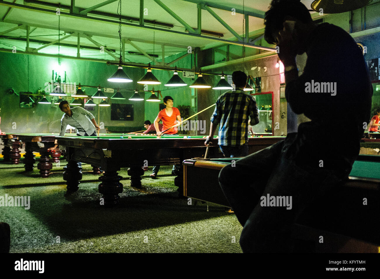 Bandar Abbas, Iran - December 14, 2013. Young Iranian men are playing billiard at a billiard hall in Bandar Abbas. Stock Photo