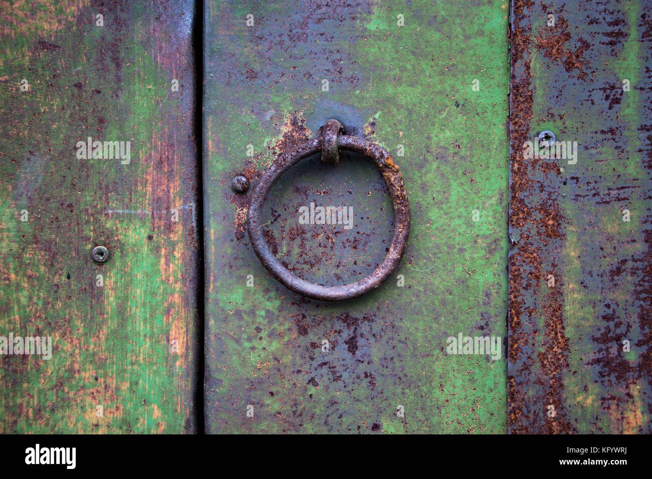 Mechanism or knob for knocking and opening the door or gate. Over time, the iron surface and paint on the product covered with cracks and rust. Stock Photo