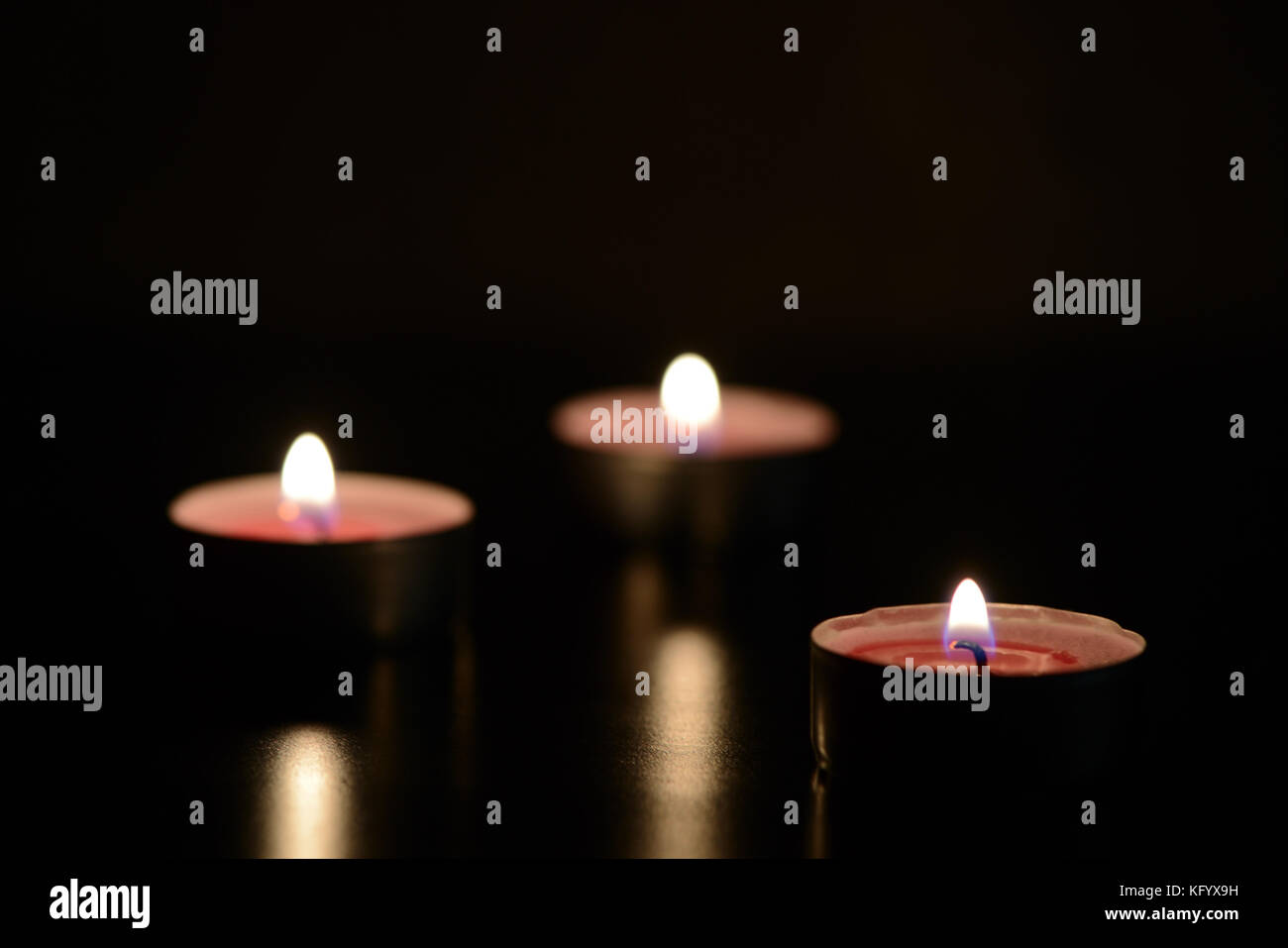 Three burning candles in the dark Stock Photo Alamy