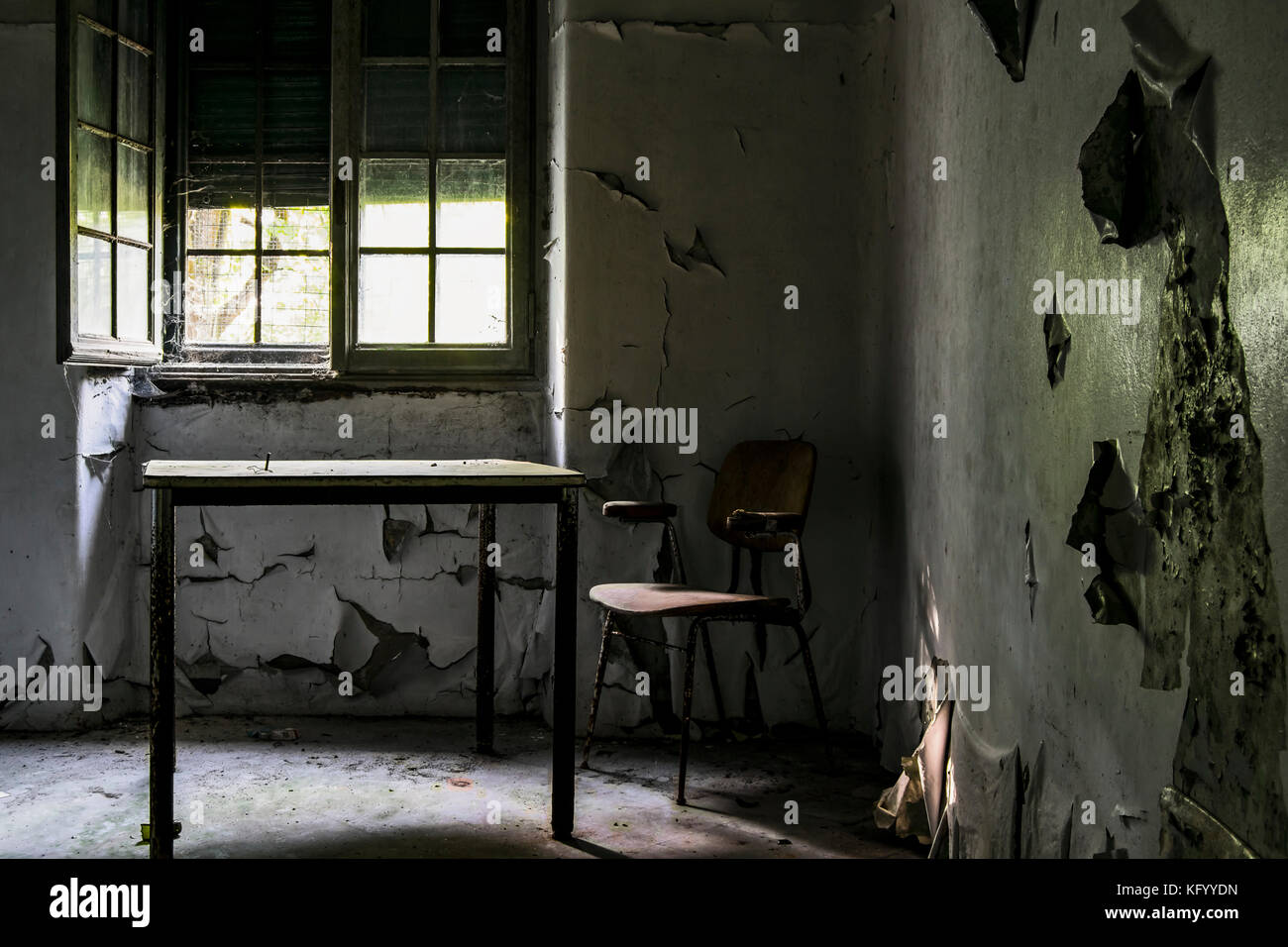 a scary shot of a chair in darkness, in a room of an abandoned