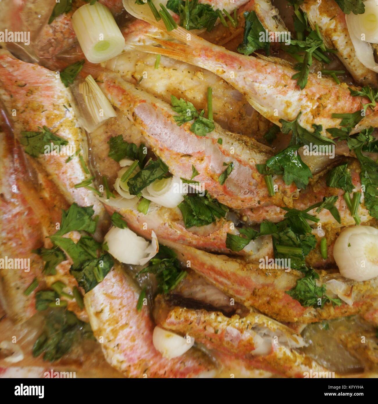 Small sea fish baked on a baking try, top view. Stock Photo