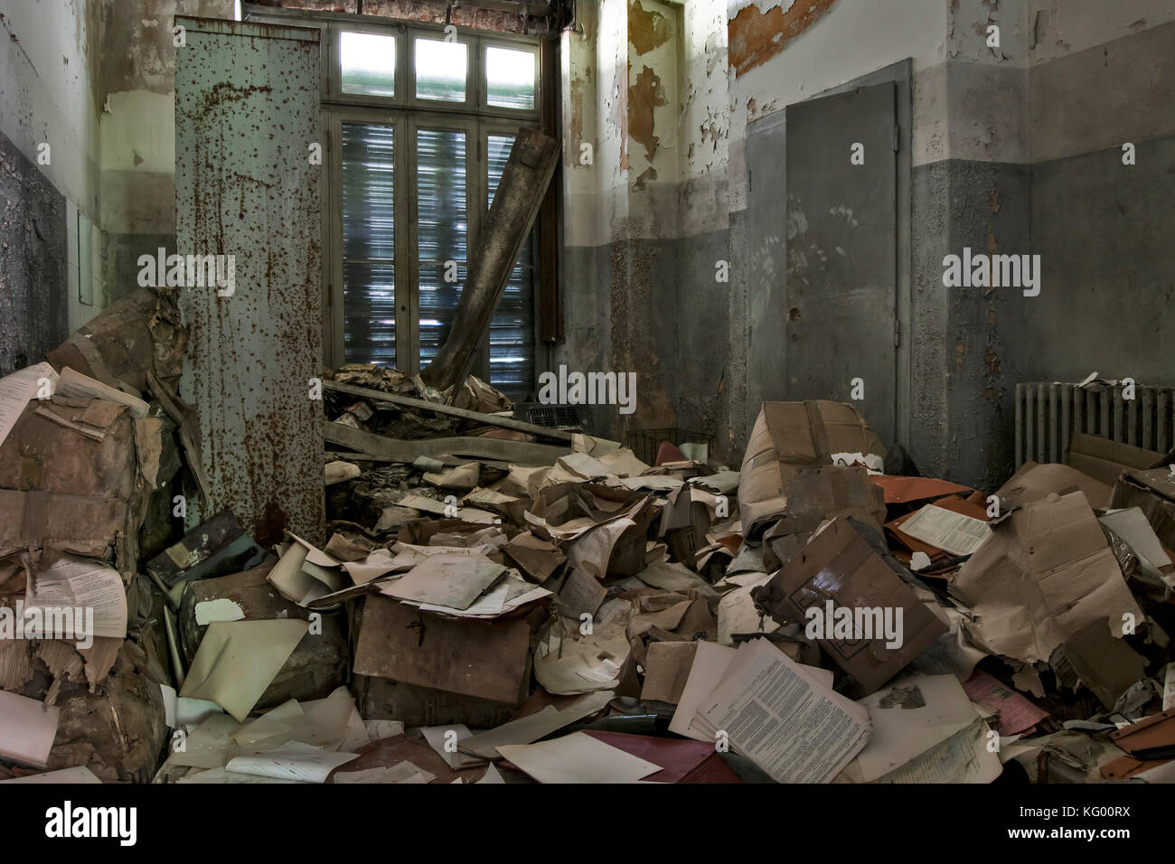 a room full of papers scattered on floor in a room of an abandoned madhouse Stock Photo