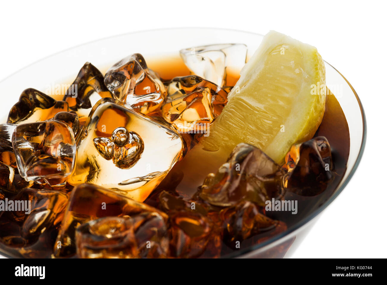 glass full of fresh cola with ice cubes and lemon slice, on white background Stock Photo