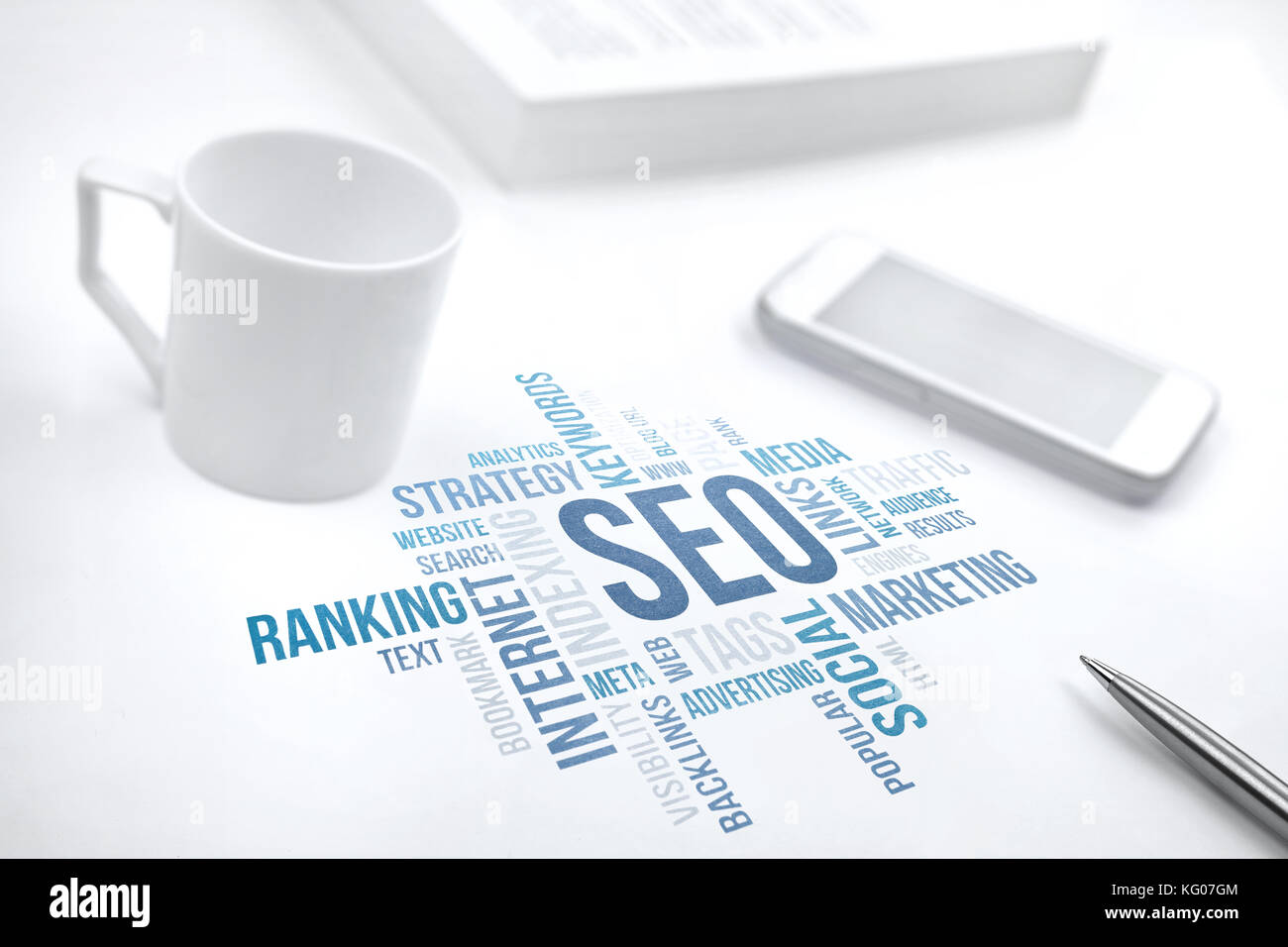 Seo, search engine optimization, business concept word cloud. Print document, smartphone, book, pen and coffee cup. Blue toned. Stock Photo
