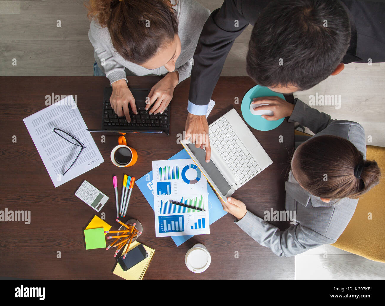 Group of Business People Working on an Office Desk Stock Photo - Alamy