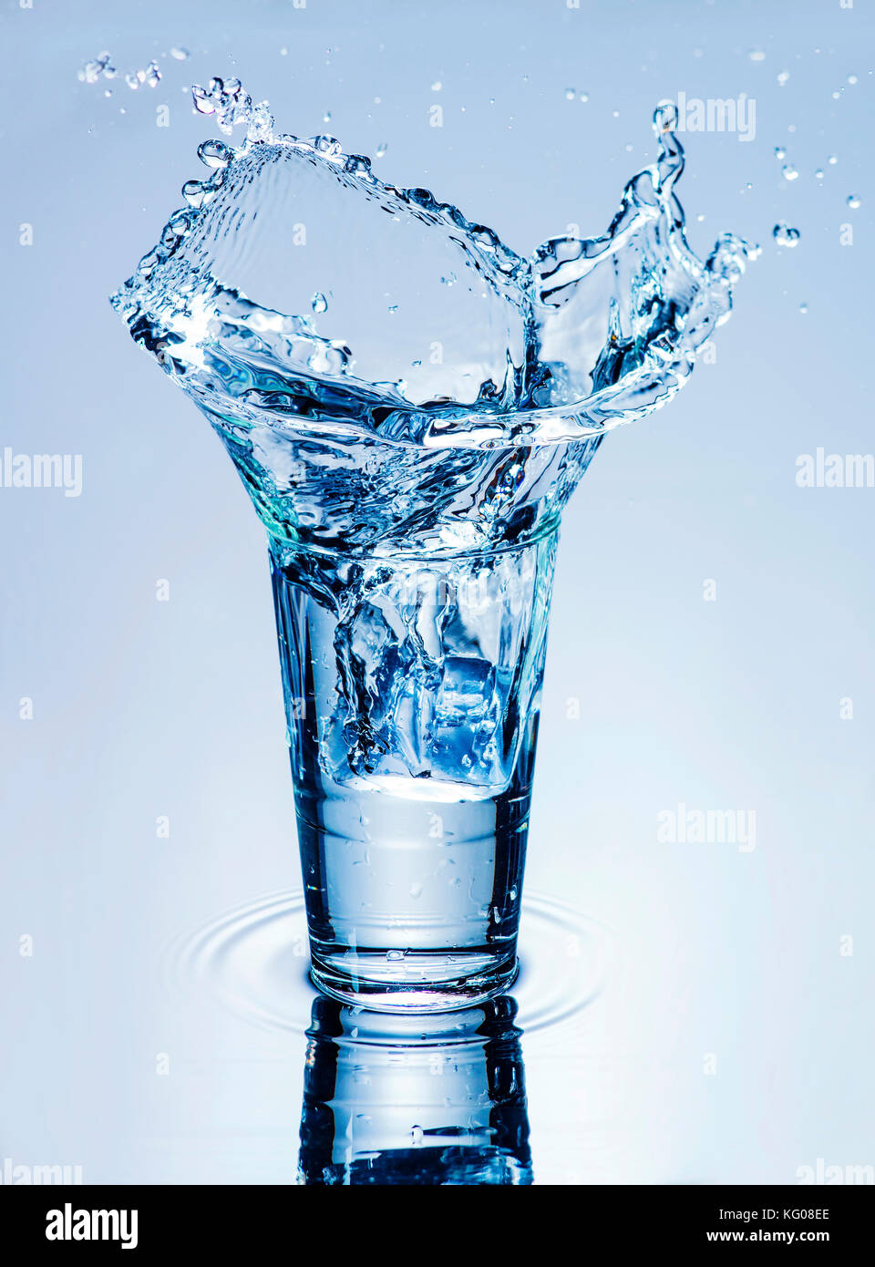 icecube splashing into a glass of water Stock Photo - Alamy