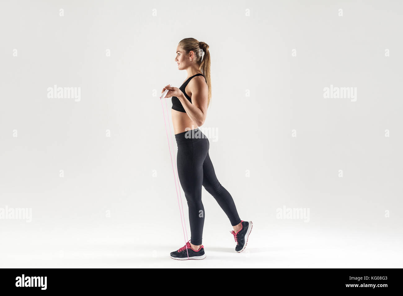 Skip Rope Side View Side view. Attractive woman holding skipping rope and looking forward ...