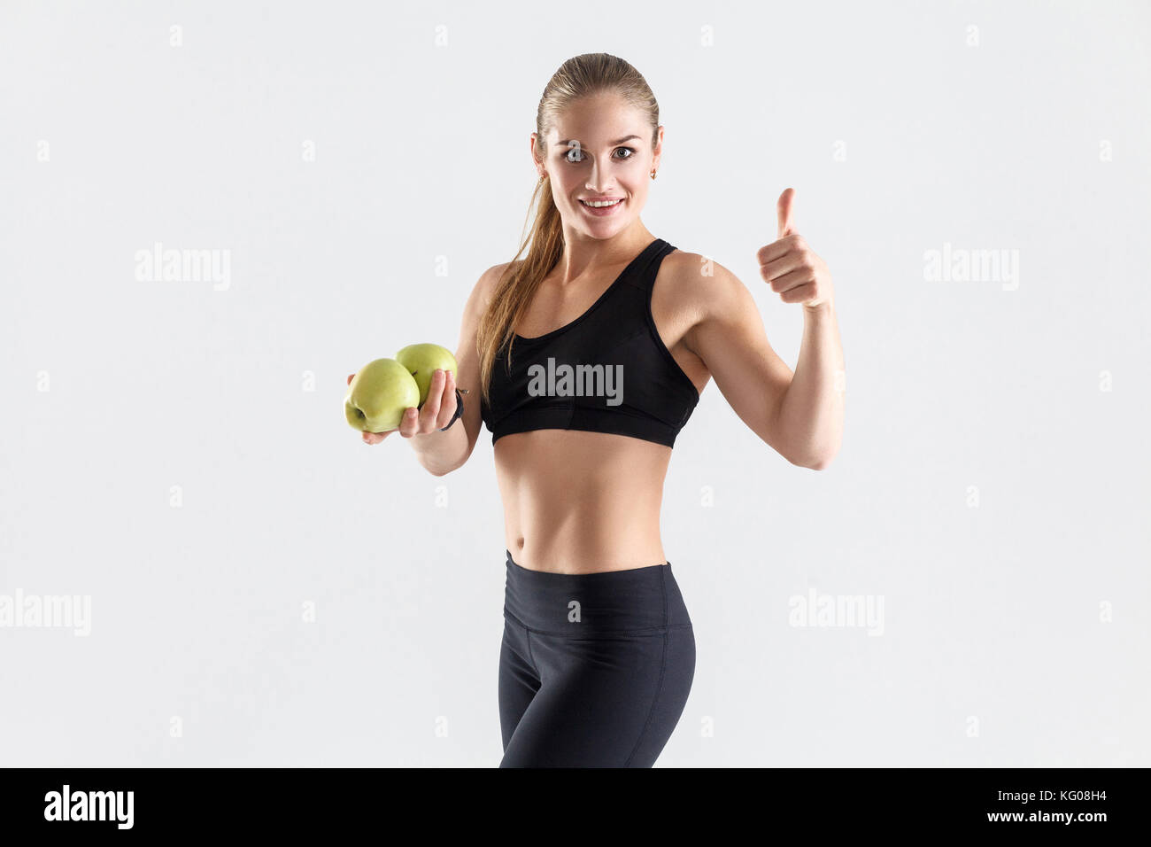 Healthy, diet concept. Happiness woman holding apple and thumbs up. Studio shot Stock Photo