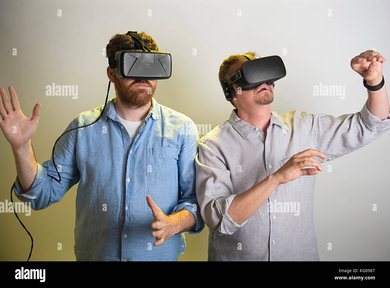 Two men using the Oculus Rift VR headsets, version 2 and 3. Stock Photo