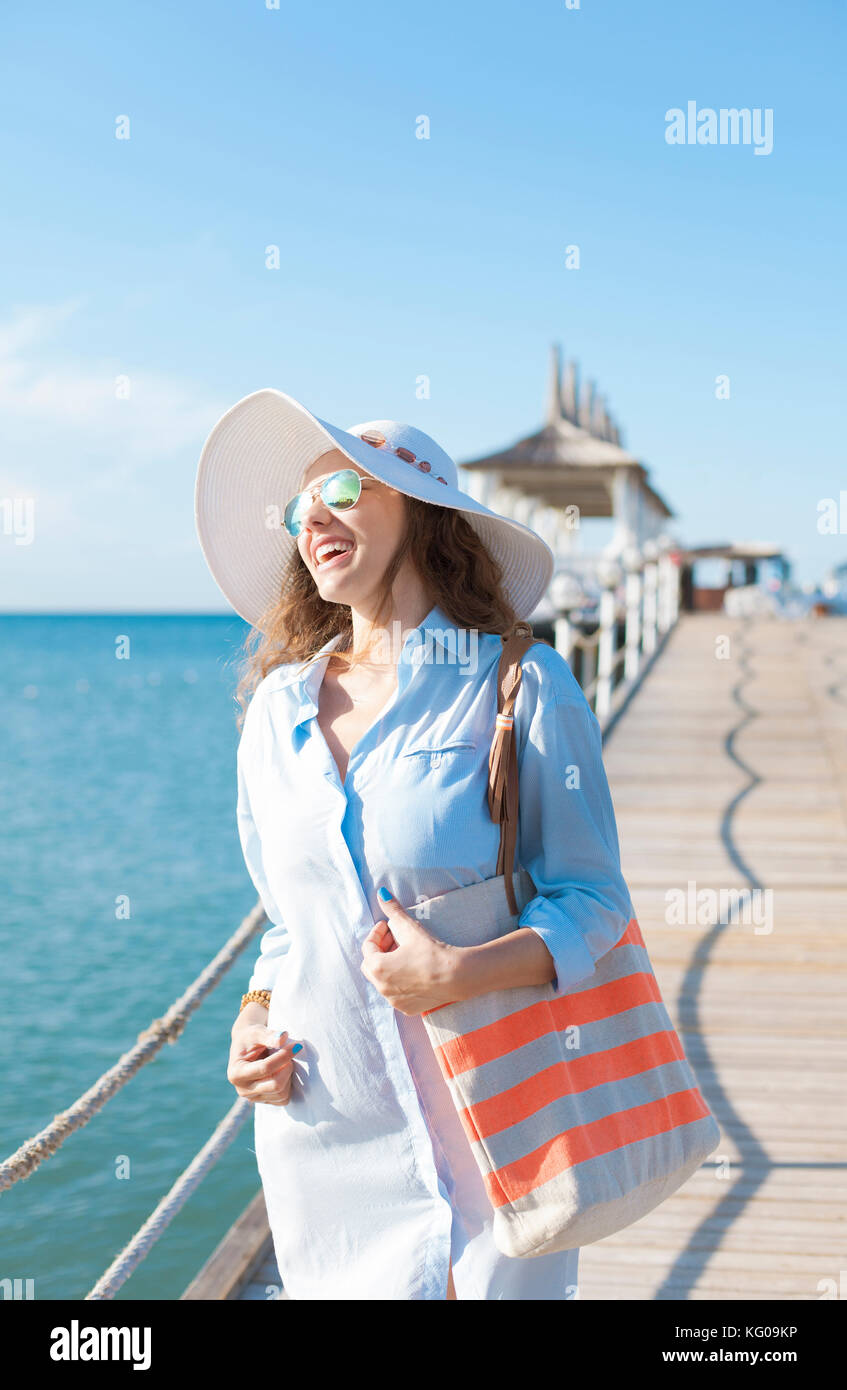 Happy young woman posing over blue sky Stock Photo - Alamy