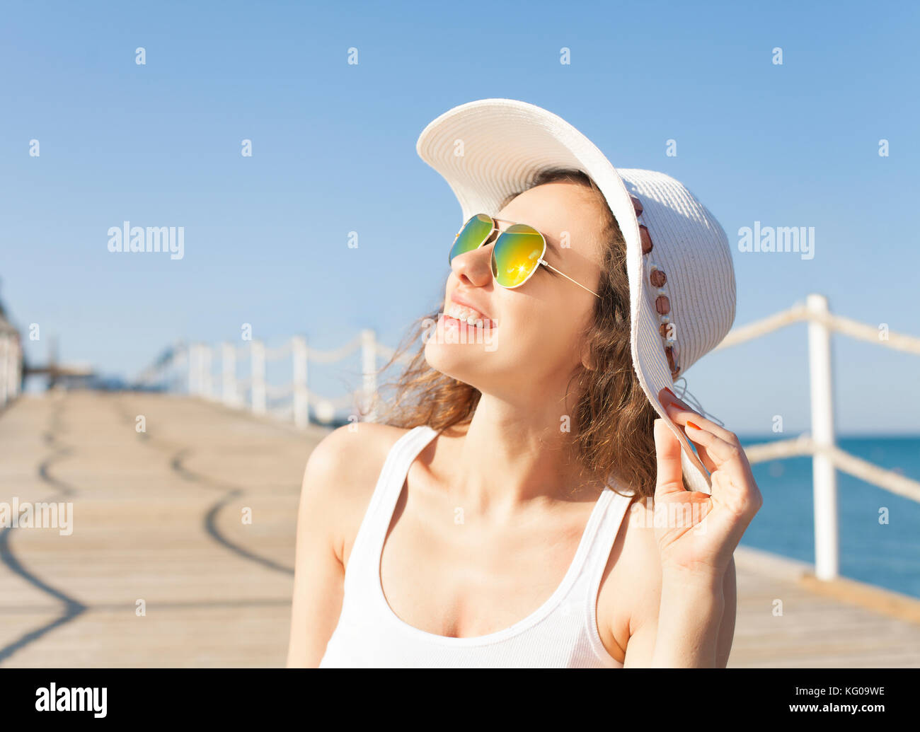 Happy young woman posing over blue sky Stock Photo - Alamy