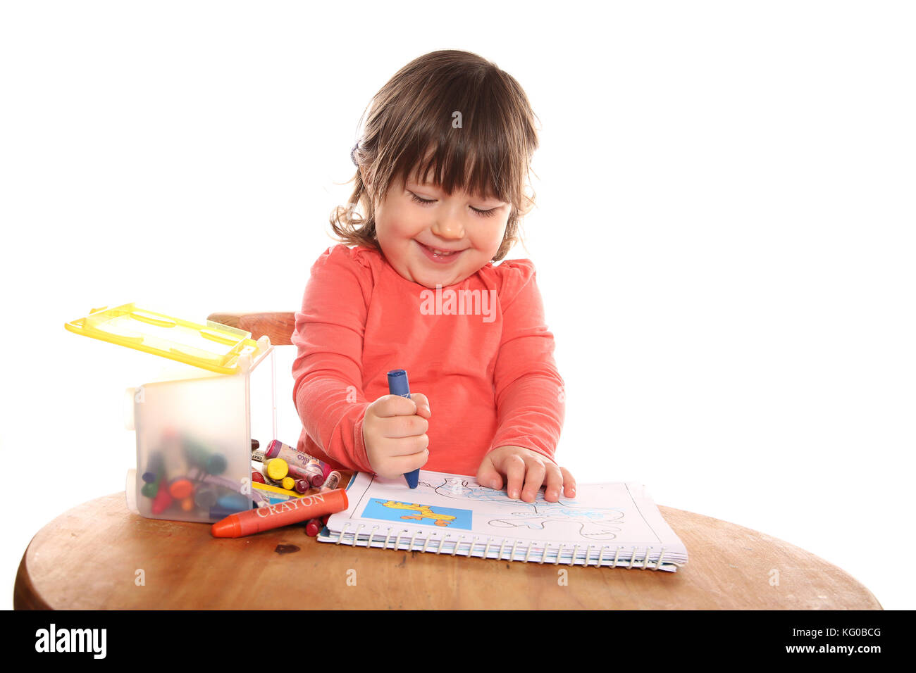 toddler girl colouring with crayons Stock Photo