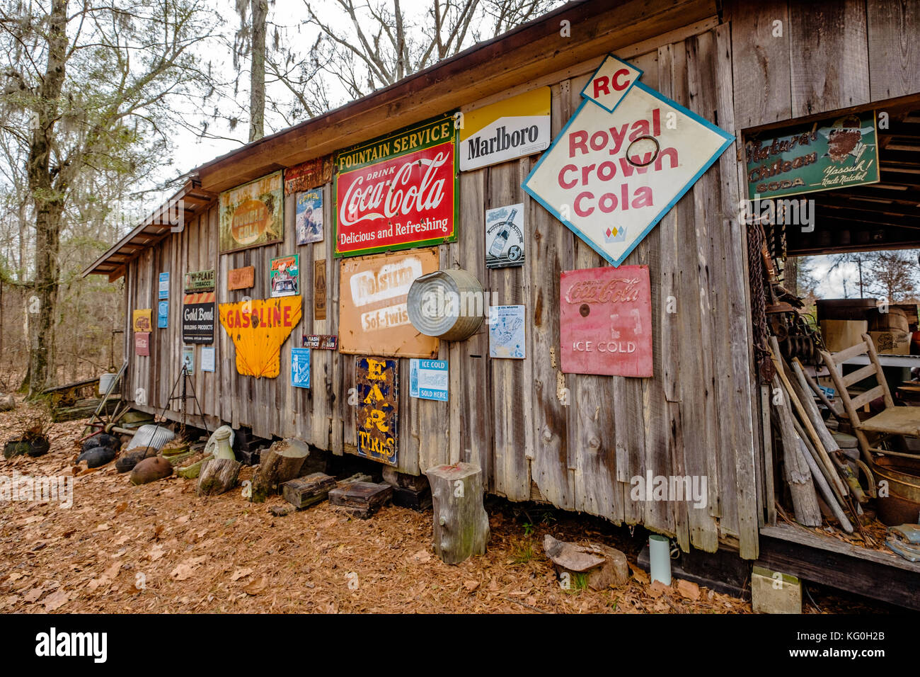 Old cabin exterior wall with antique signs hanging in rural Alabama, USA. Stock Photo