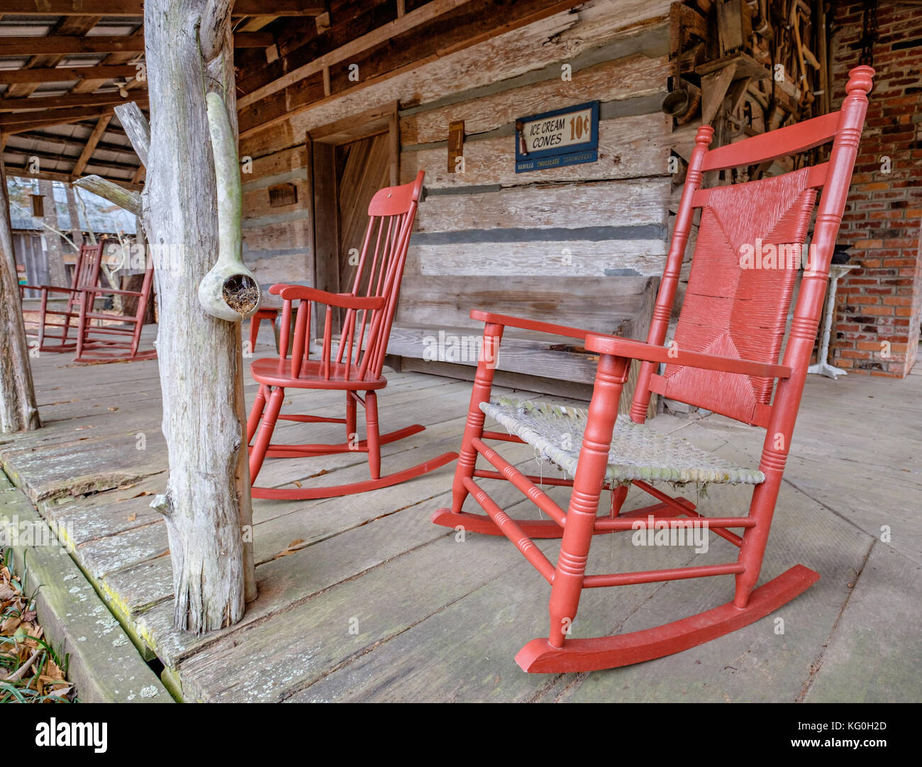 Old fashioned white rocking chairs on the front porch of an old cabin in rural Alabama, USA. Stock Photo