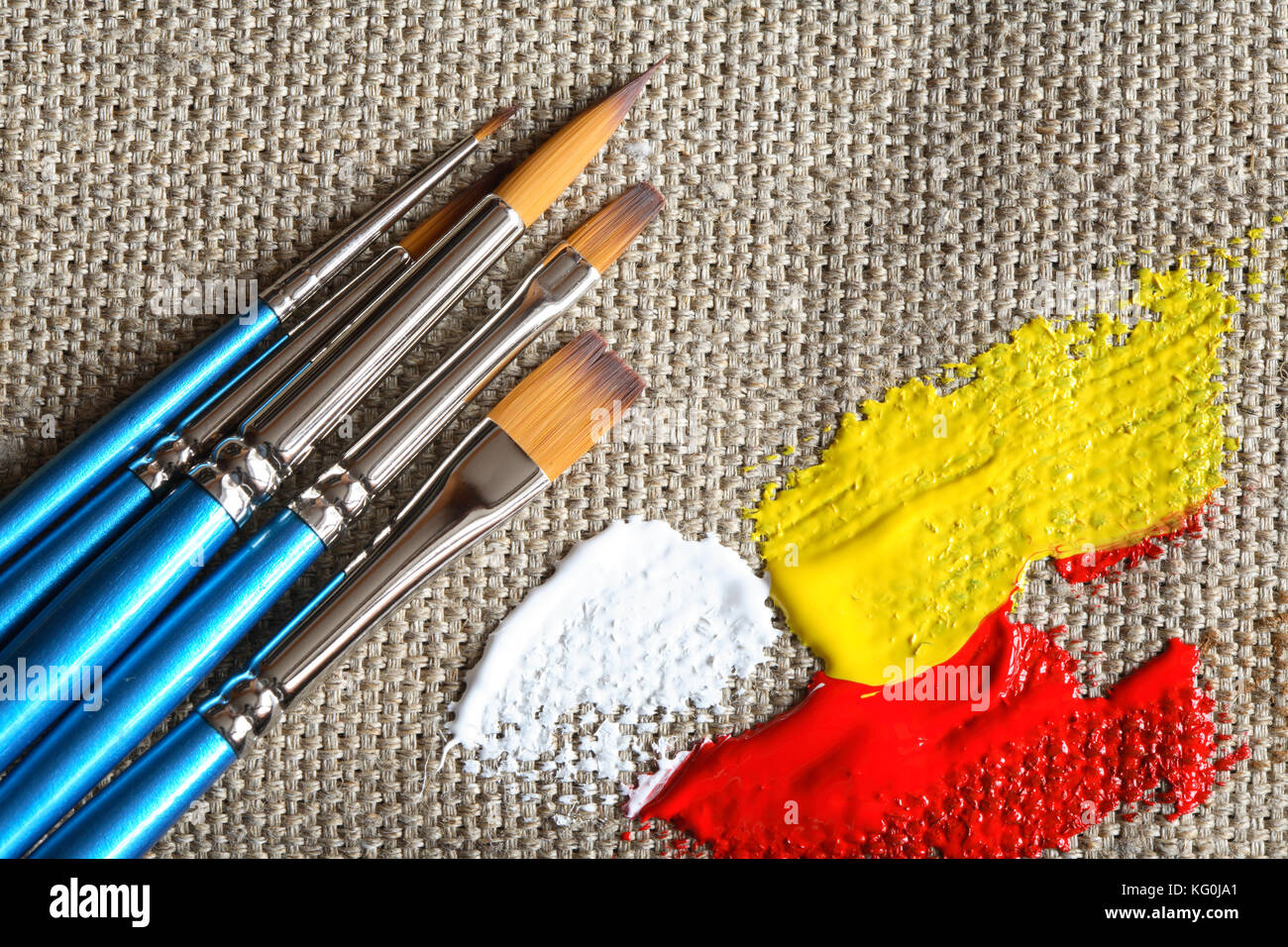 Set of paintbrushes and color paint on canvas background Stock Photo - Alamy