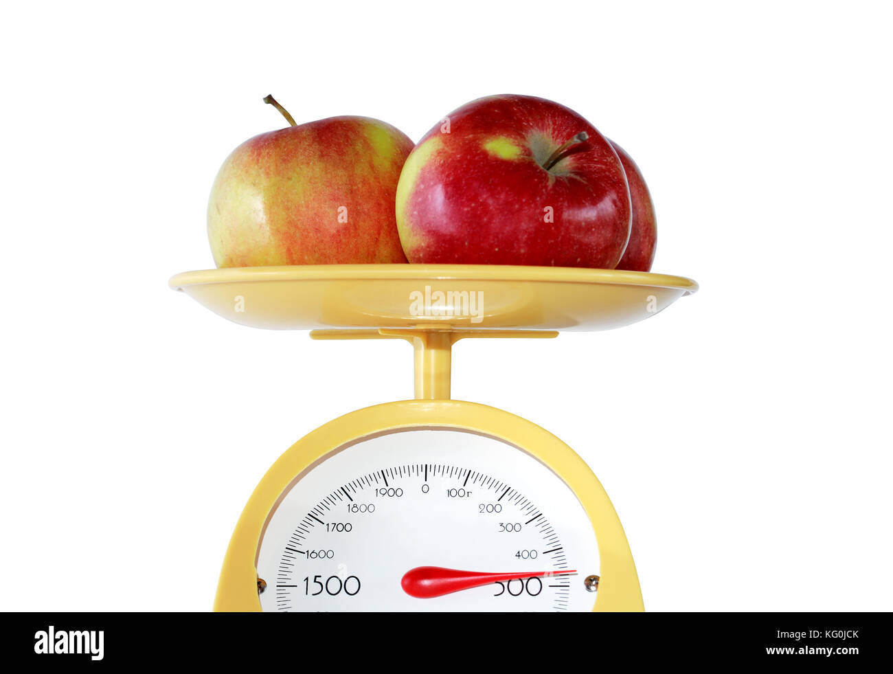 Closeup of three apples lying on weight scale. Isolated on white with