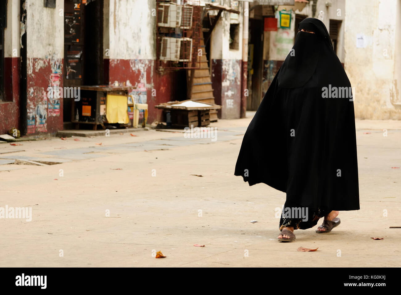 Muslim woman in the street of African city dressed in the chador Stock Photo