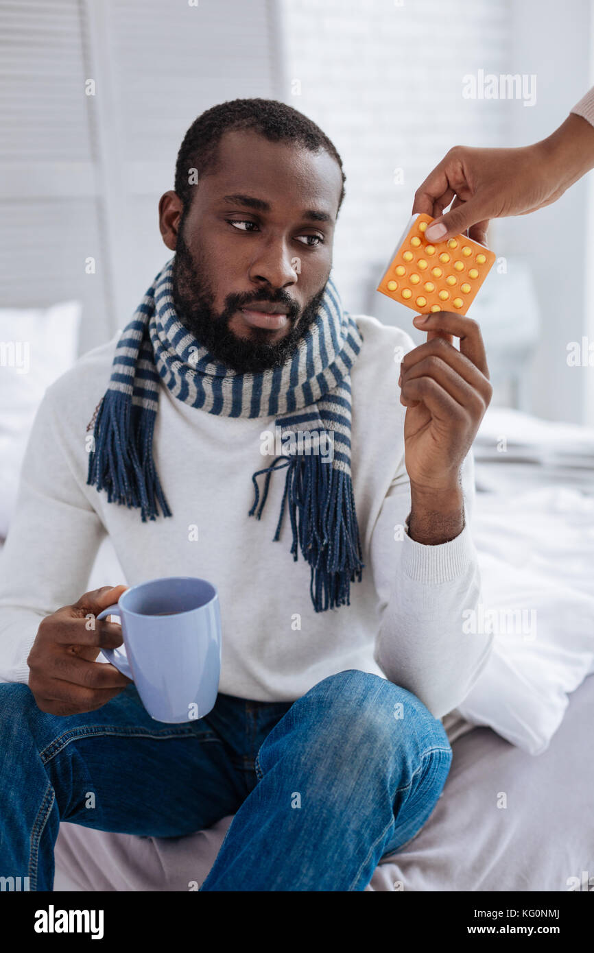 Unemotional tired man getting his pills Stock Photo