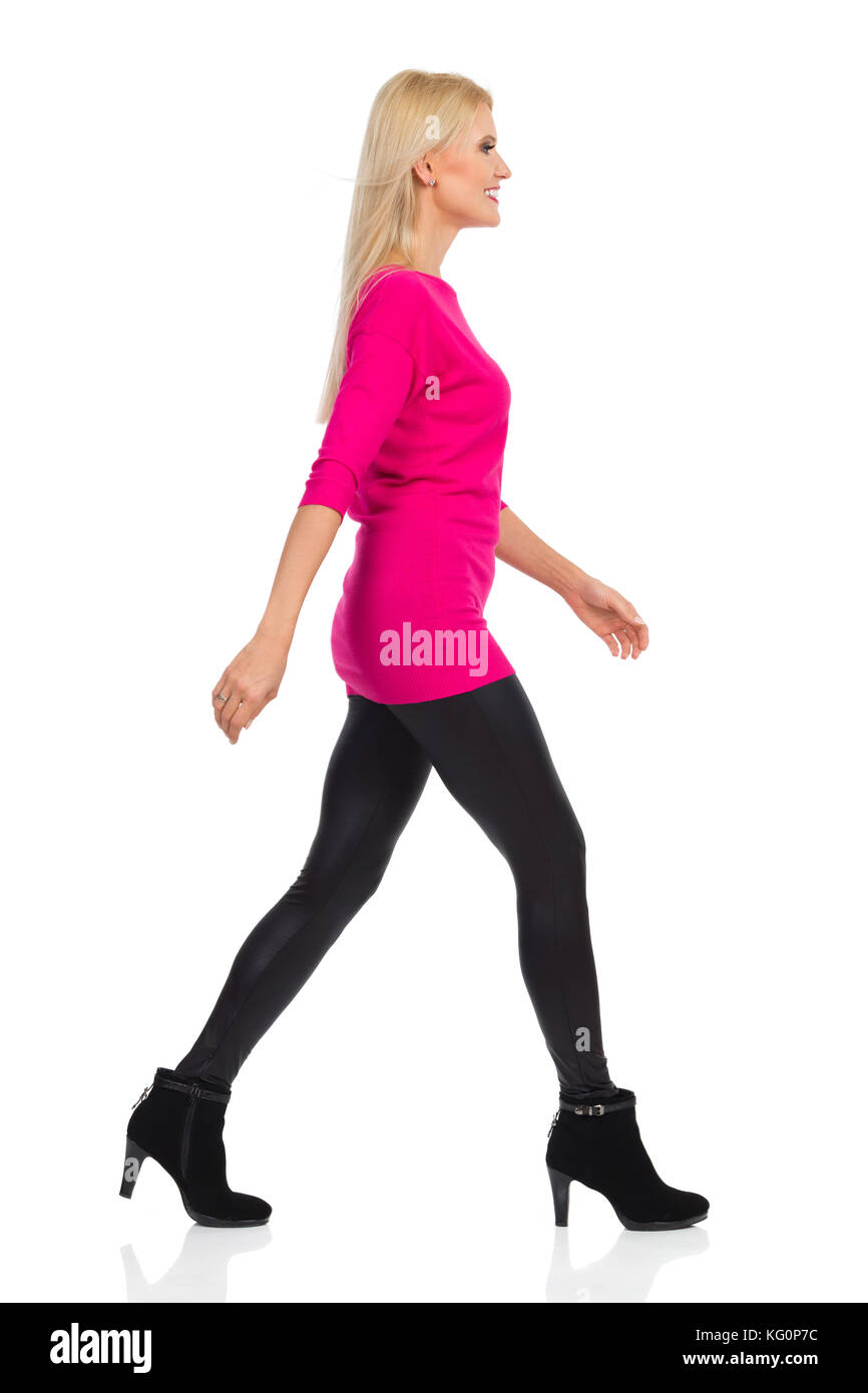 Blond woman in black leggings, high heels and pink sweater is walking and  smiling. Side view. Full length studio shot isolated on white Stock Photo -  Alamy