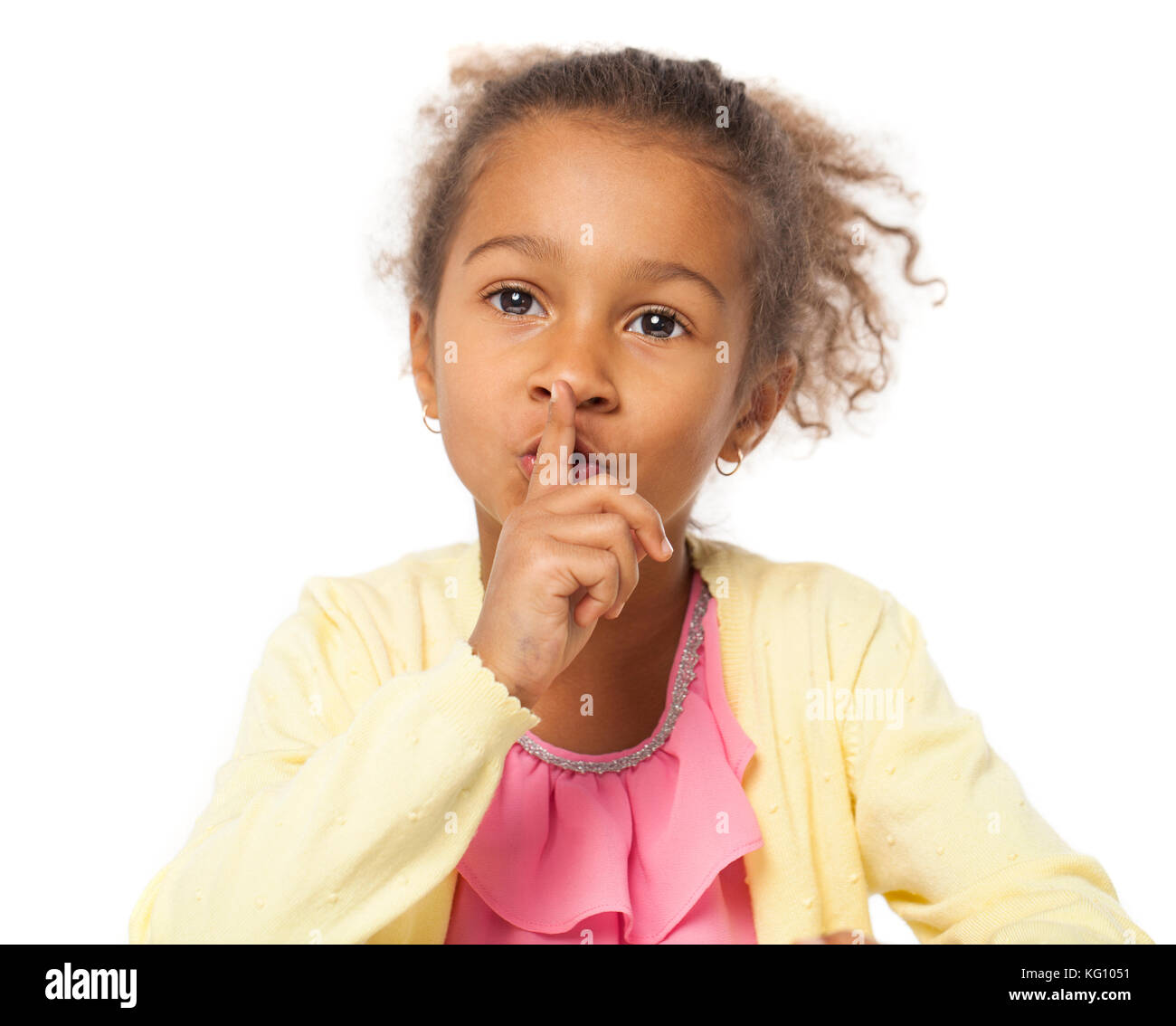 Young beautiful african Little girl has put forefinger to lips as sign of silence, isolated on white background Stock Photo