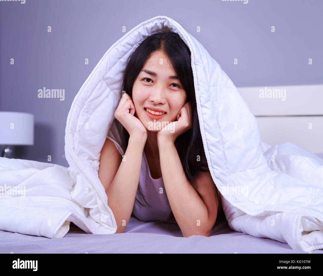 happy woman hiding under blanket on bed in the bedroom Stock Photo Alamy