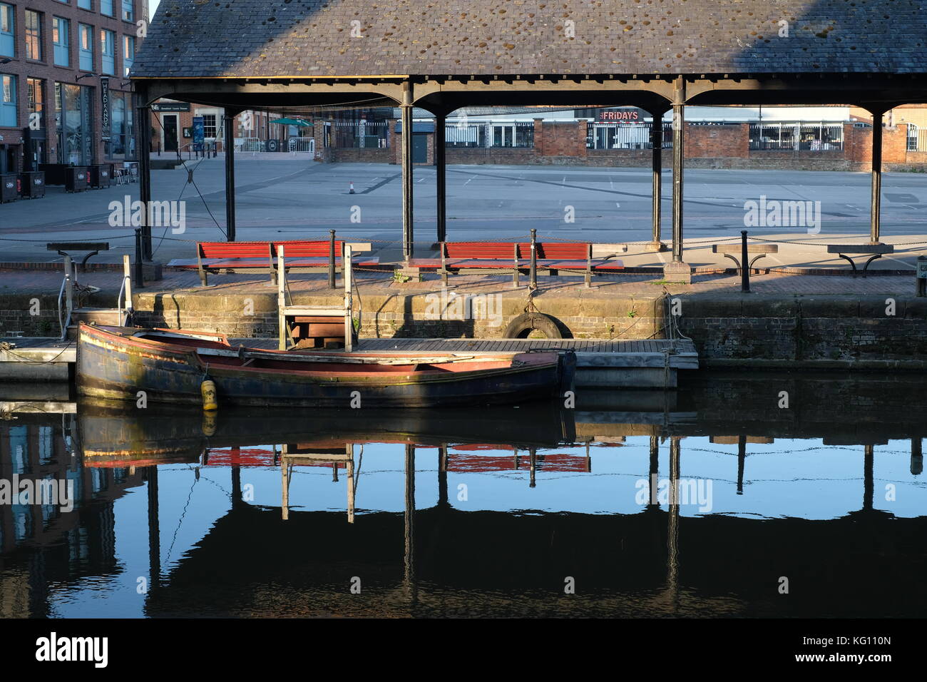 Boats and reflections in the water of The Barge Arm in Gloucester Docks