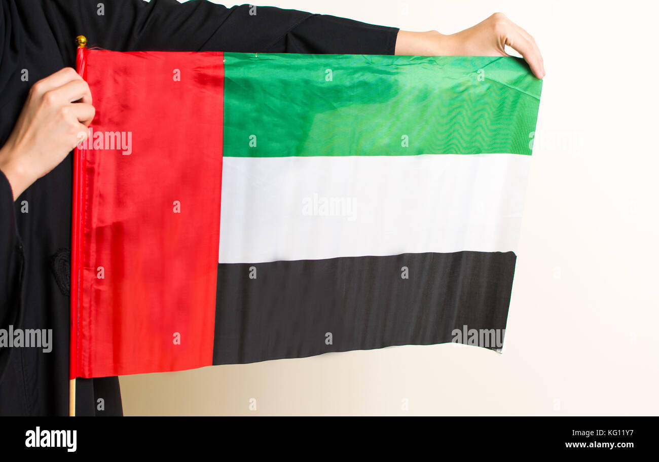 Woman in abaya holding the United Arab Emirates flag Stock Photo