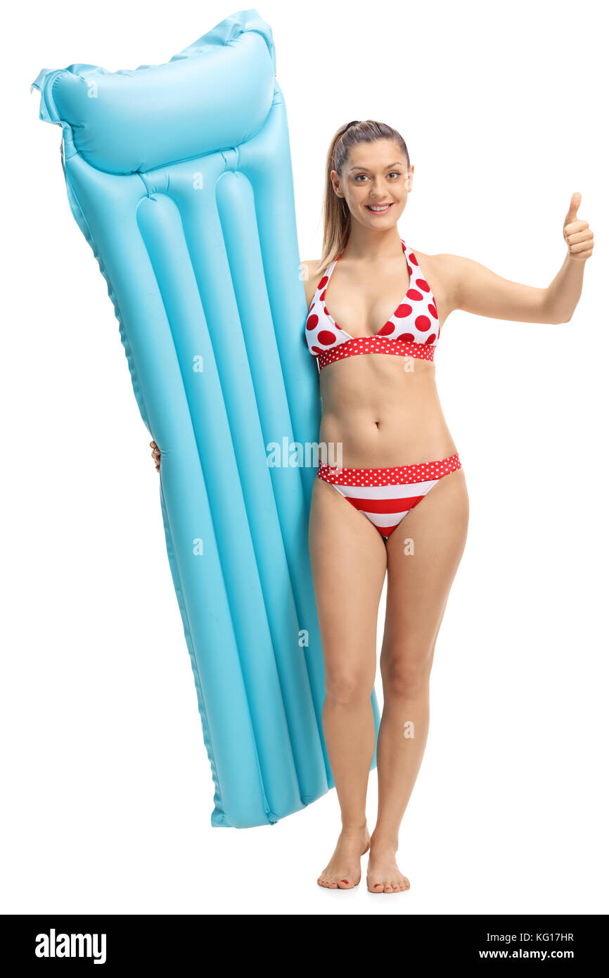 Full length portrait of a young woman with an air mattress making a thumb up sign isolated on white background Stock Photo