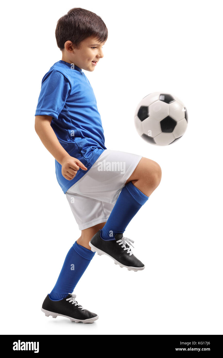 Full length profile shot of a little footballer juggling a football isolated on white background Stock Photo