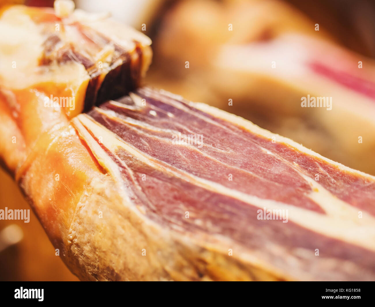 Jamon serrano. Traditional Spanish ham in the market close up. Pork leg ham on table. Meat in