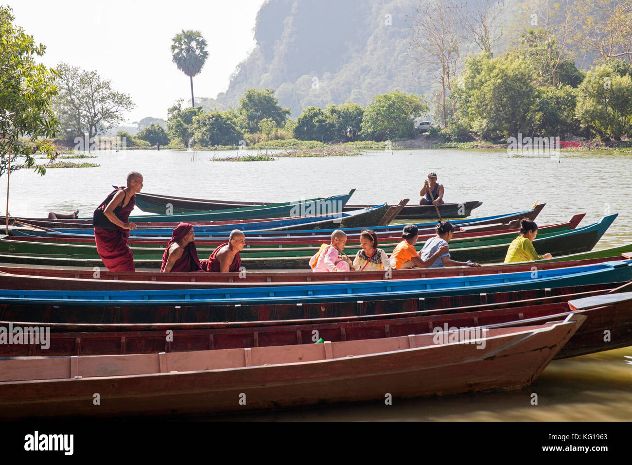 Burmese monks and local passengers in wooden boat near the town Hpa-an, Kayin State / Karen State, Myanmar / Burma Stock Photo