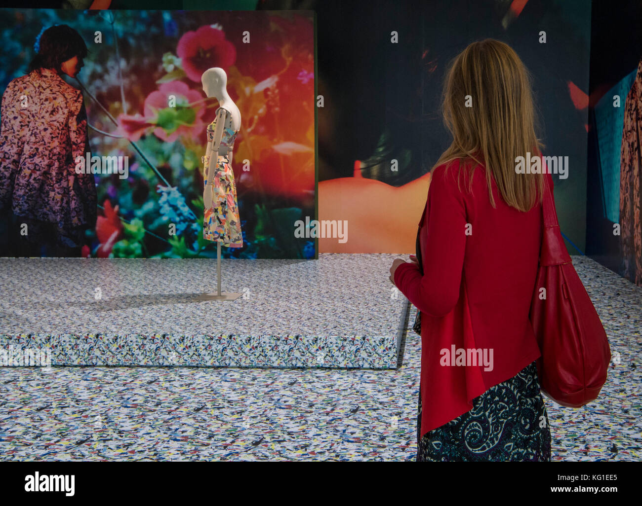A woman walking by the exhibits in the exhibition 