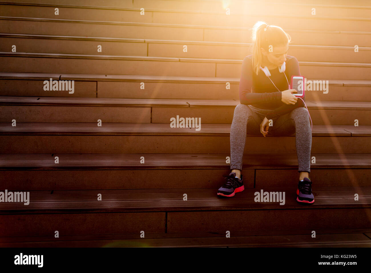 Young woman resting after jogging on stairs outdoor Stock Photo - Alamy