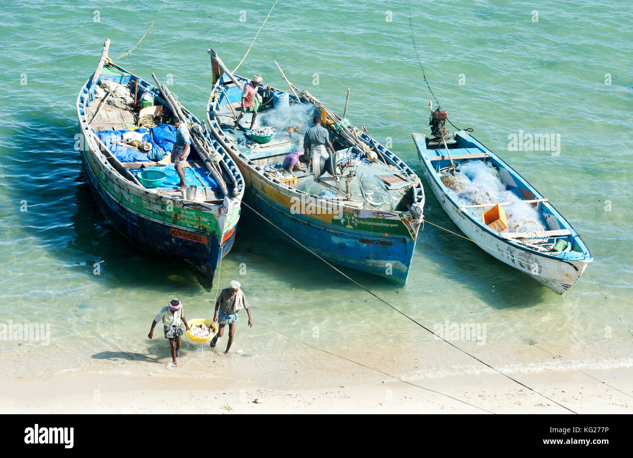 Fisherman carrying fish to land and tidying up their colourful fishing