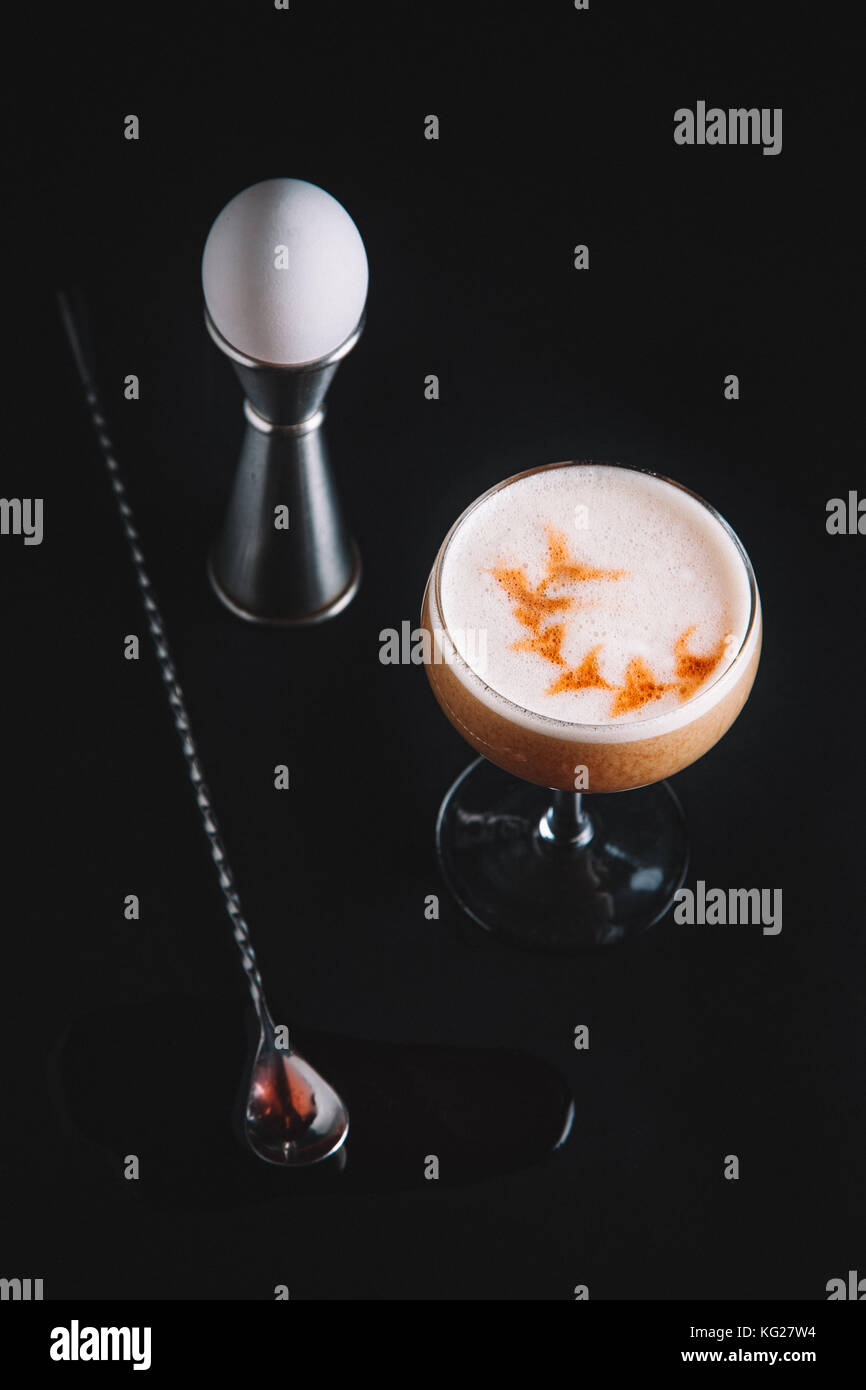 Brown liquor cocktail with egg foam on dark background Stock Photo