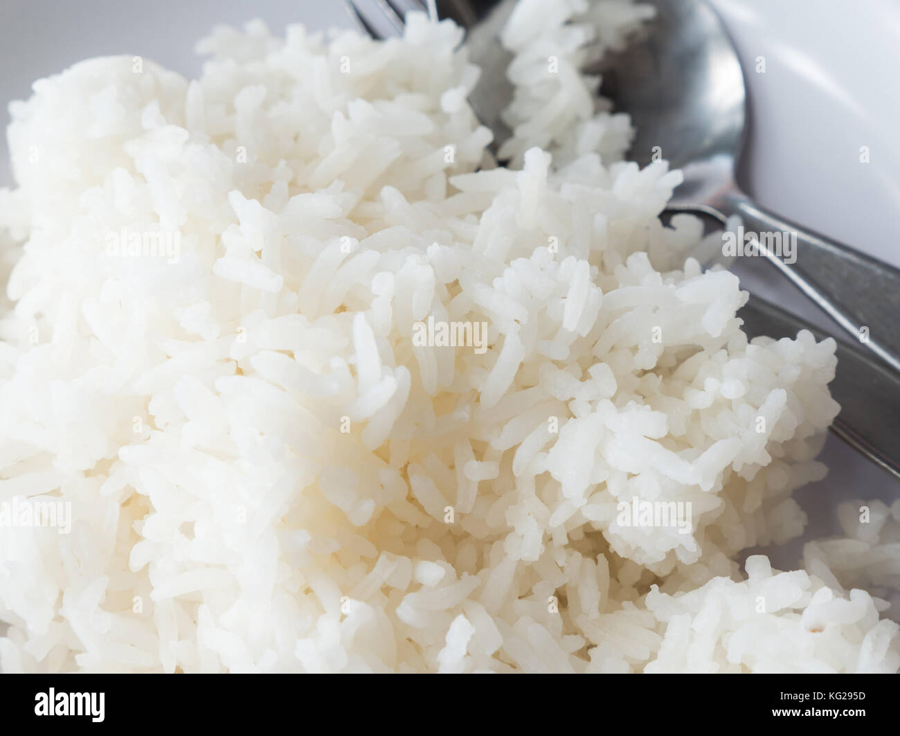 Soft cooked rice (Thai Jasmine rice) is serving in the white plate of ...