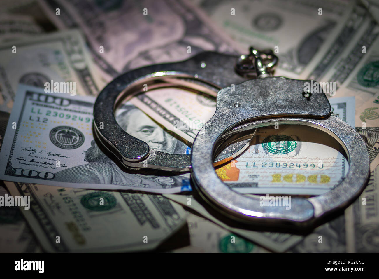 A pair of closed handcuffs on a pile of American Dollars Stock Photo