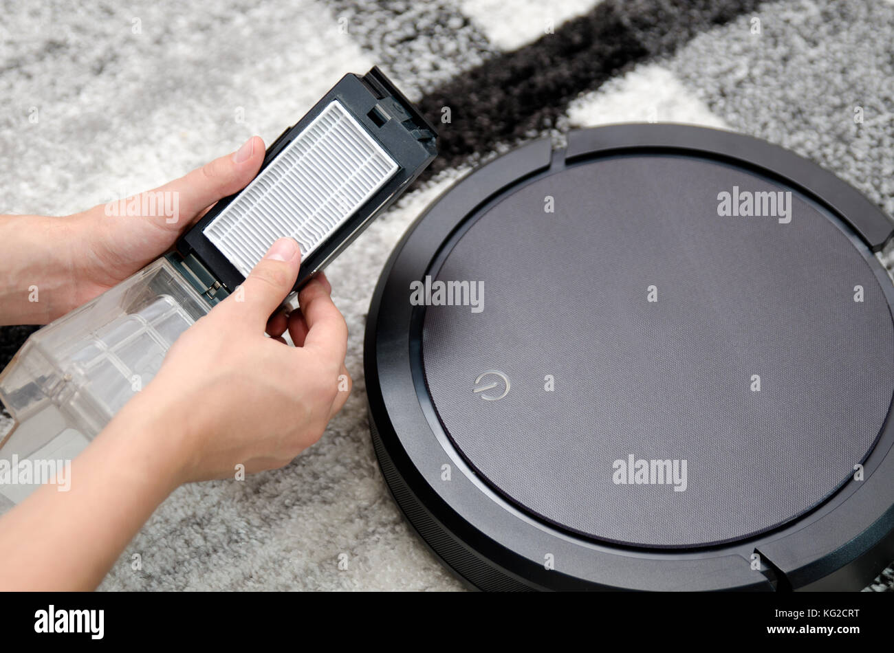 Robotic vacuum cleaner. Hepa filter cleaning. Maintenance concept. Stock Photo